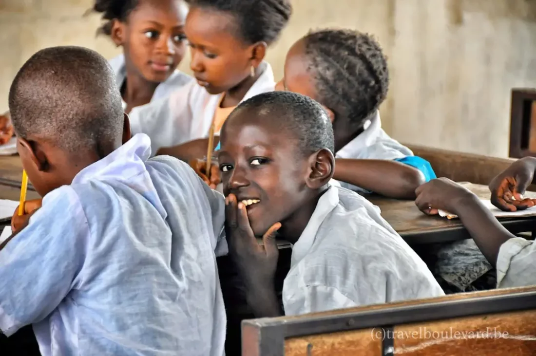Close-up of a smiling boy in a white school uniform at a school in The Gambia.