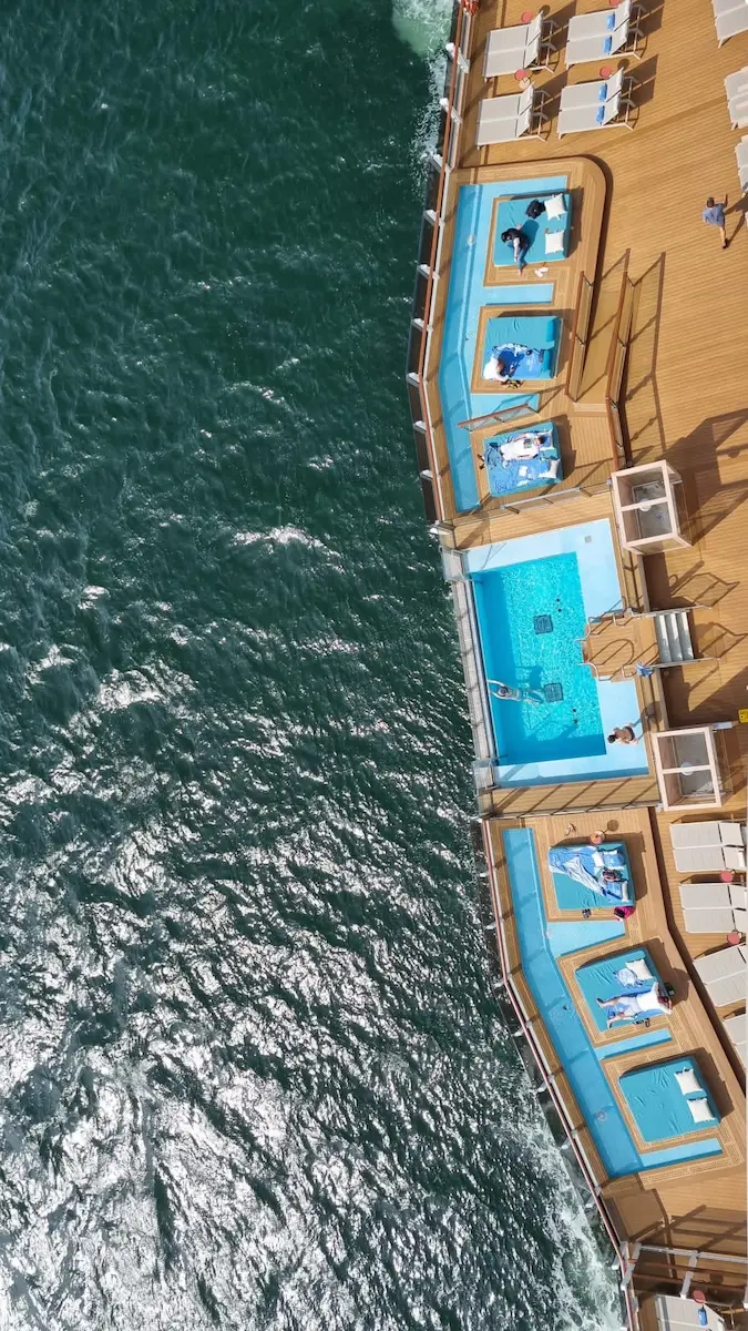 Bovenaanzicht van de infinity pools en loungebedden op de Ocean Boulevard van de Norwegian Prima.